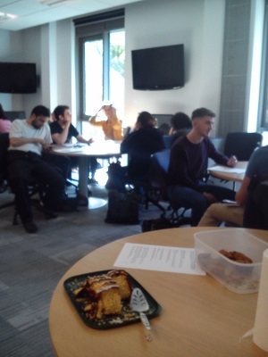 Photo of cake with blurred groups of students in the background