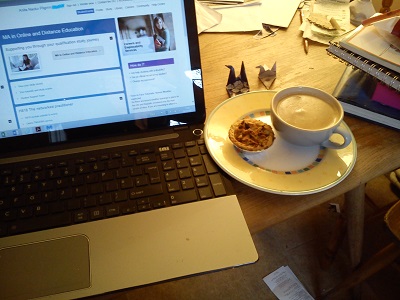 Computer open at StudentHome with cup of coffee and mince pie