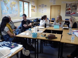 Several people sitting round tables chatting