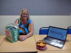 One woman sitting smiling by a laptop showing tutorial slides