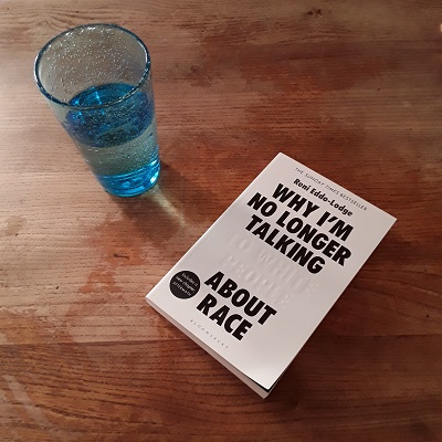Glass of water beside copy of the book Why I'm No Longer Talking (To White People) About Race