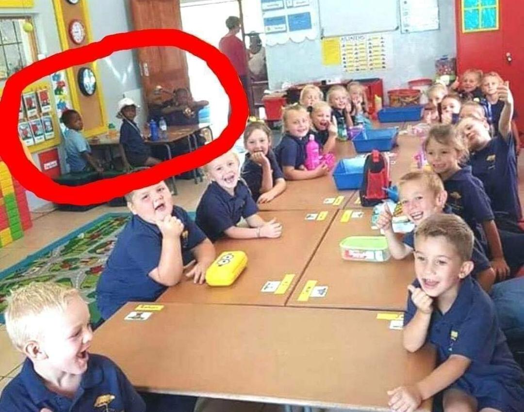 This pictures was taken within a classroom in South Africa, with seventeen Caucasian children all sitting on a large desk!