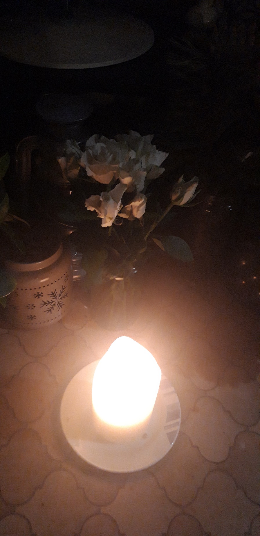 A white candle and some white roses.