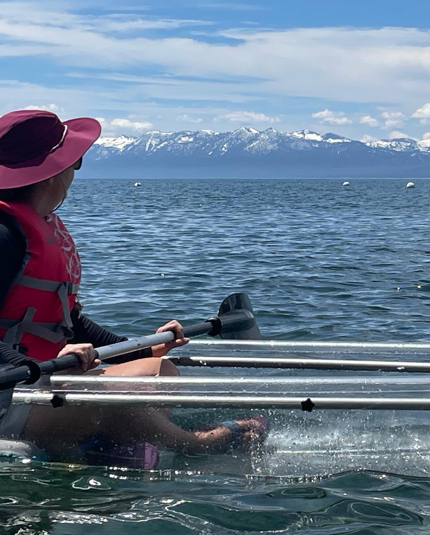 Me sitting in a kayak on Lake Tahoe with snow covered mountains in the background.