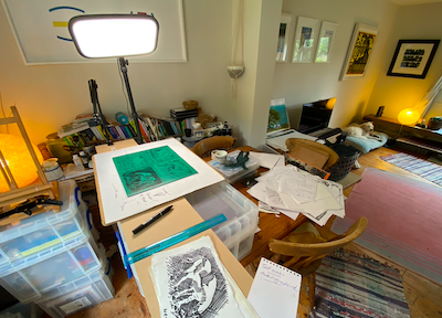 A piece of lino divided into four to try different cutting techniques, on the dining room table with our dog