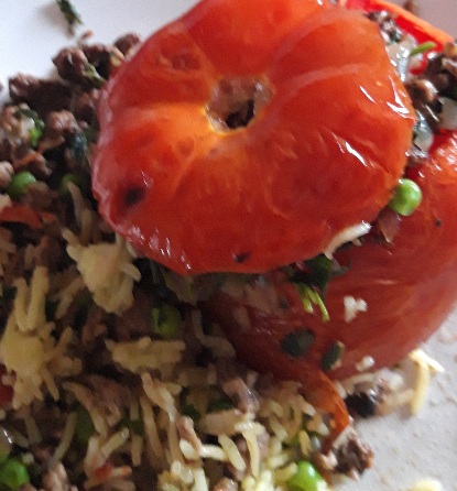 Red tomatoes stuffed with herbs & spices golden brown Quorn and  lemon rice with green sweet garden peas.