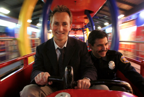 An AI-generated image of the author riding a bumper car with a New York Cop.