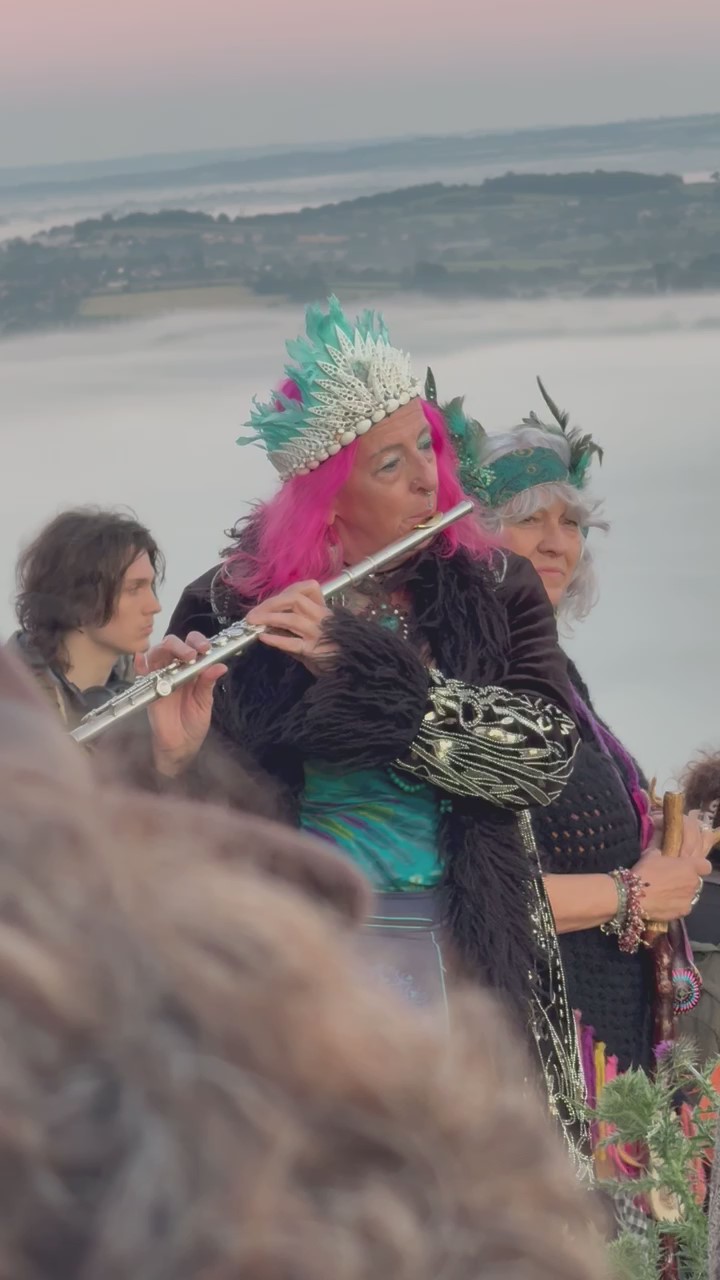 A flautist with the mists of Avalon rising in the background.