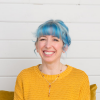 Blue hair, yellow sweater, big smile